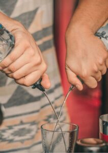 Mergers and Acquisitions Person Pouring from Two Soda Bottles