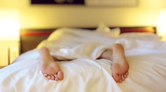 Person Lying in Bed with Only Their Feet Showing