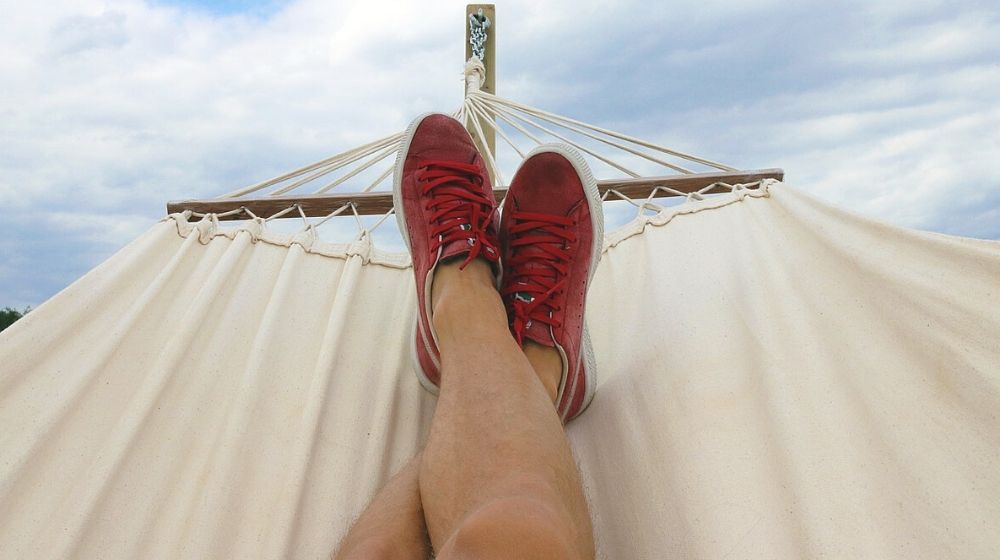 Person on Hammock Wearing Red and White Sneakers