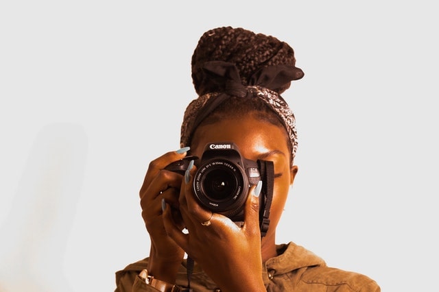 Woman adjusting a camera lens before taking a picture