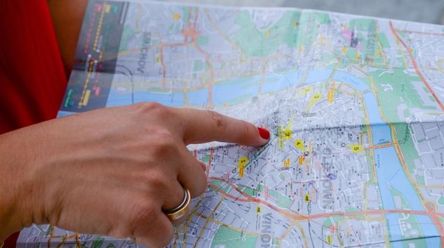 Woman Pointing to a Spot on a Map