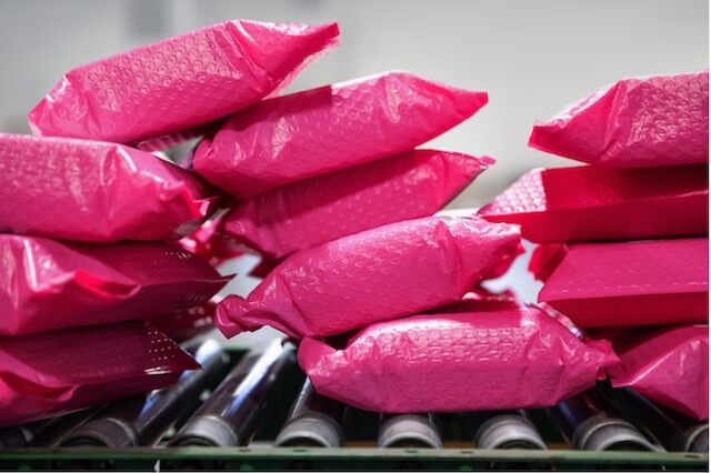 Bright pink packaging materials laying on conveyor belt