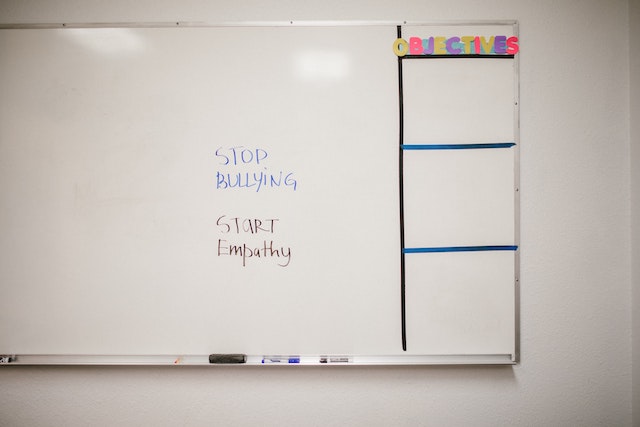 White board with words &quot;stop bullying start empathy&quot; written in black marker