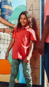 Boy standing near a height ruler painted on a wall