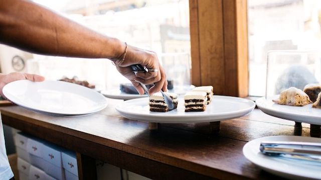 Cafe worker placing cake on a plate