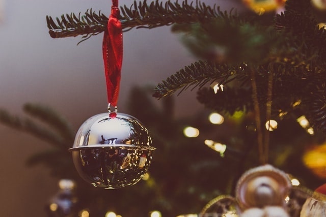 Close up of a silver bell hanging from a tree