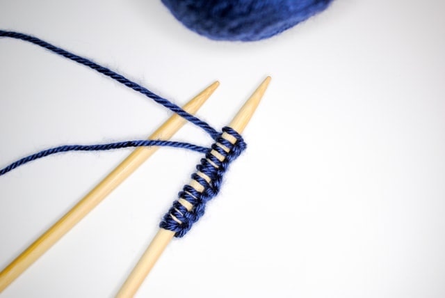 Close-up of knitting needles with blue yarn