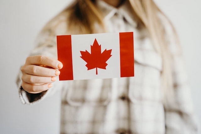 Closeup of a woman holding a Candian flag decal