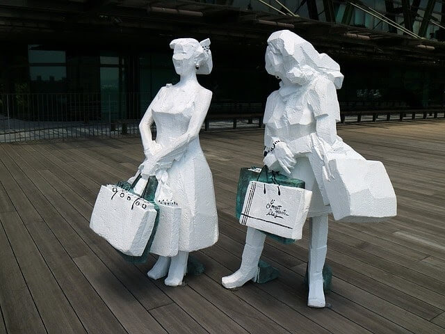 Small white statues that resemble women shopping