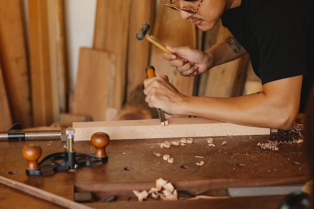 Man crafting a table leg out of wood