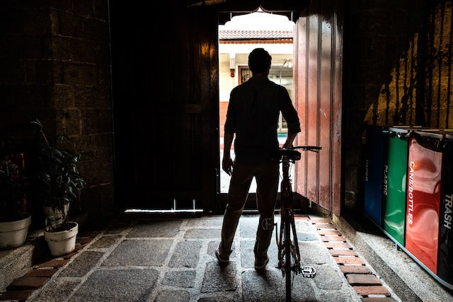 Man standing near an entryway with a bike