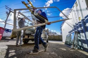 Men loading glass windows onto a truck