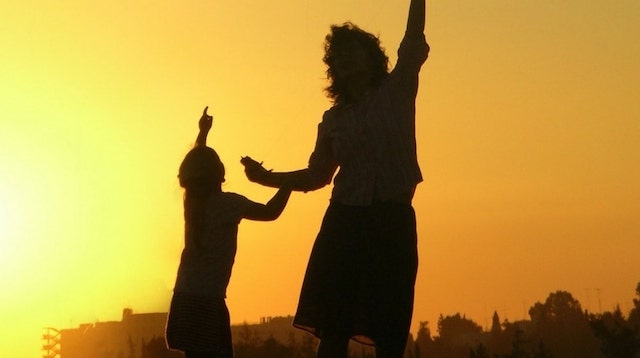 Mother and child pointing at something in the sky