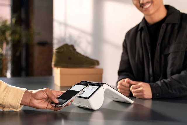 Person using smartphone with Poynt Smart Terminal