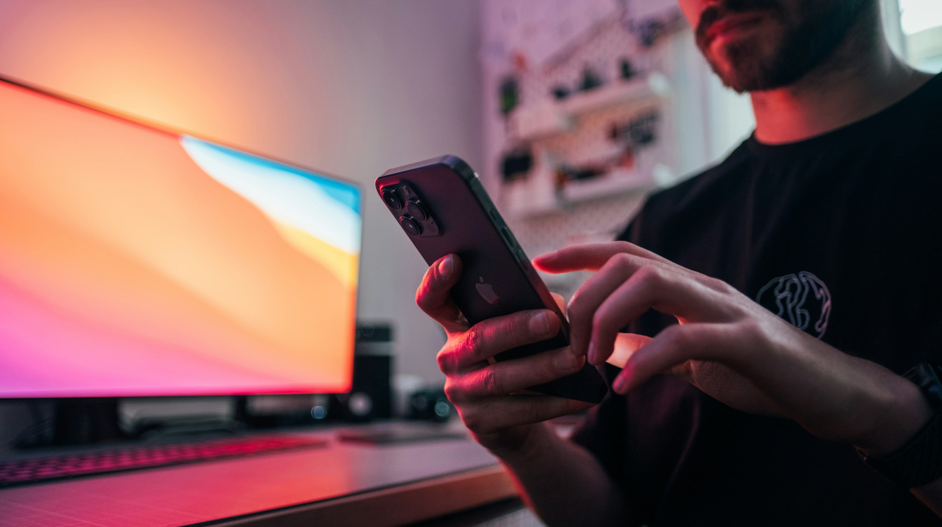 Man sitting at a desk using his iphone