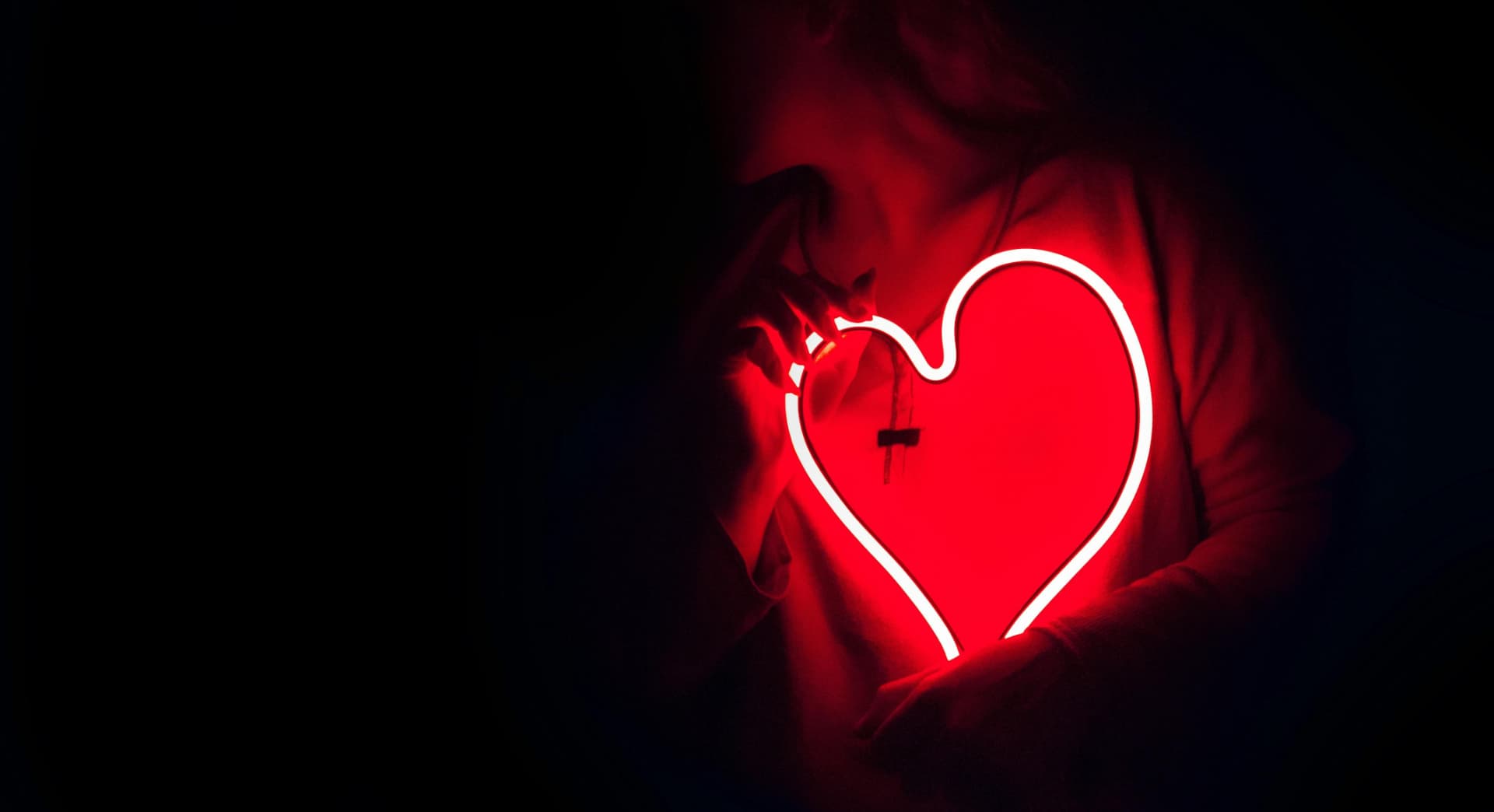 Woman holding a neon heart as a Valentine's marketing idea