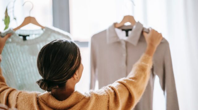 Woman holding up two blouses