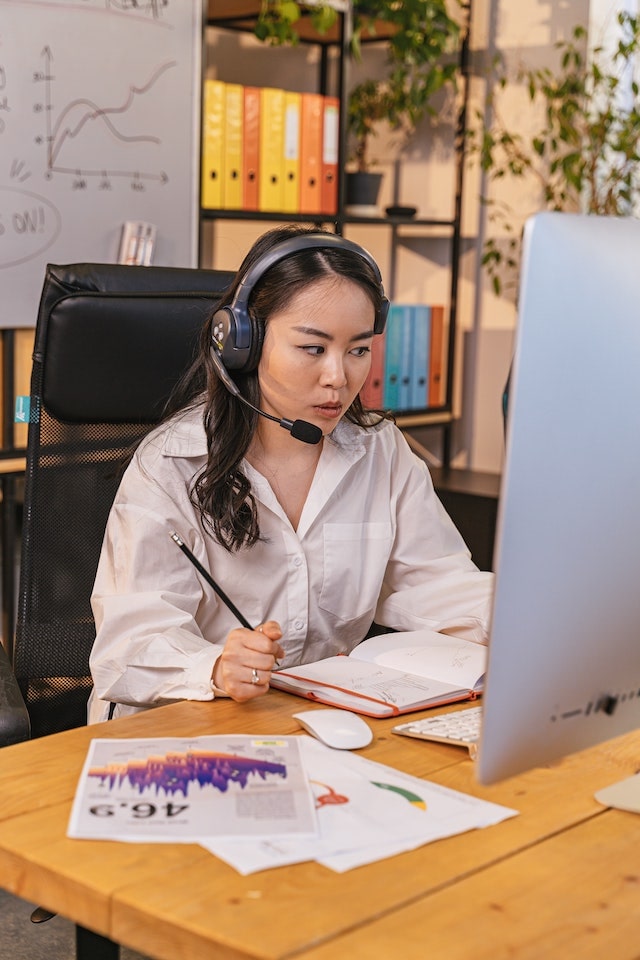 Woman sitting at a desk talking on a headset