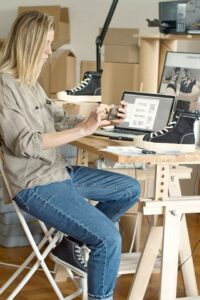 Woman taking photo of a shoe with boxes in background