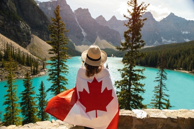 Woman wrapped in Canadian flag enjoying scenic view