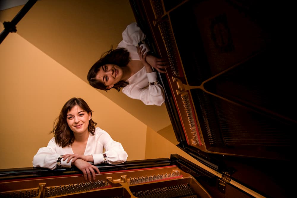 Imagen de Aurelia posando en su piano, reflejada en el mismo