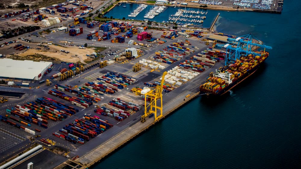 Imagen de un puerto recibiendo barcos con mercancía para entregar en containers.