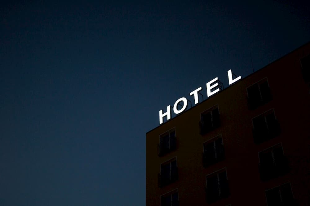 Imagen de un hotel con su cartel luminoso encendido por la noche.