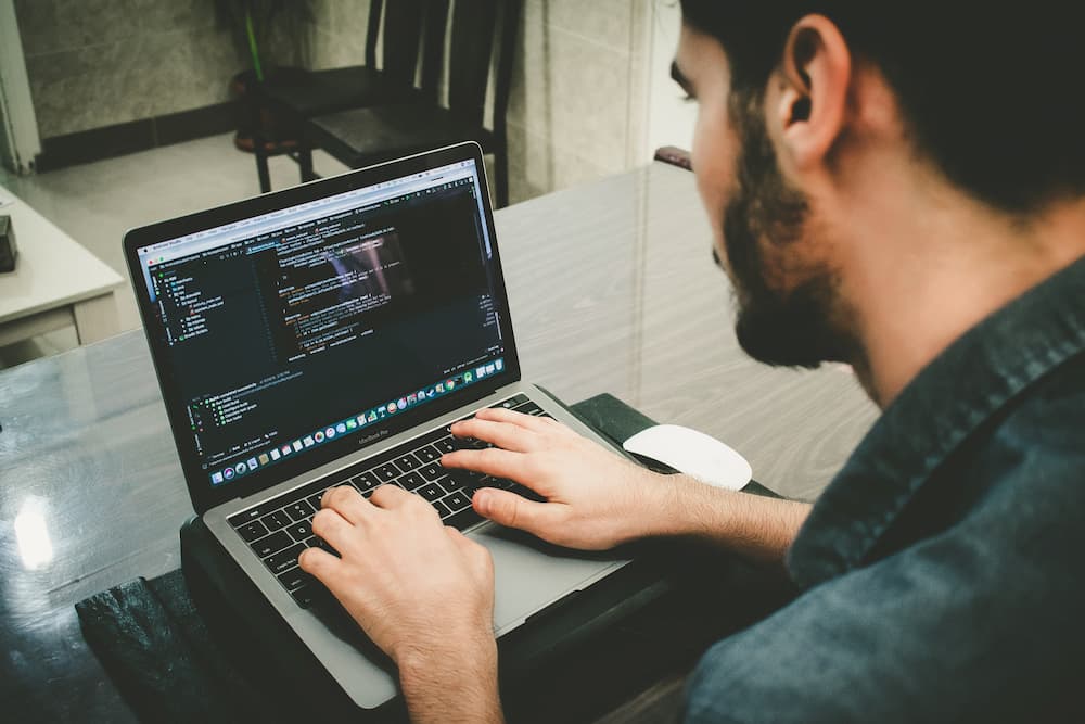 Imagen de un chico escribiendo código con un portátil