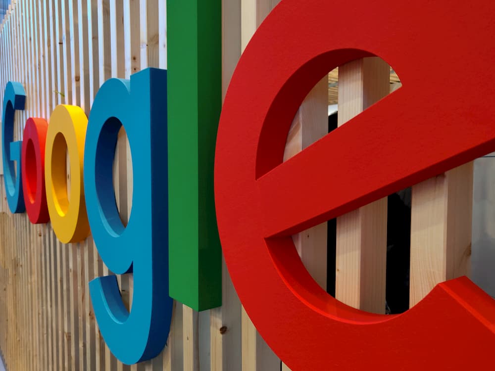 Imagen del logo de Google escrito en letras gigantes apoyadas en una pared.