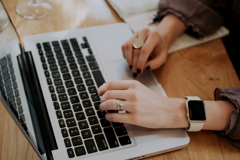 Imagen de una mujer escribiendo en un Macbook Pro