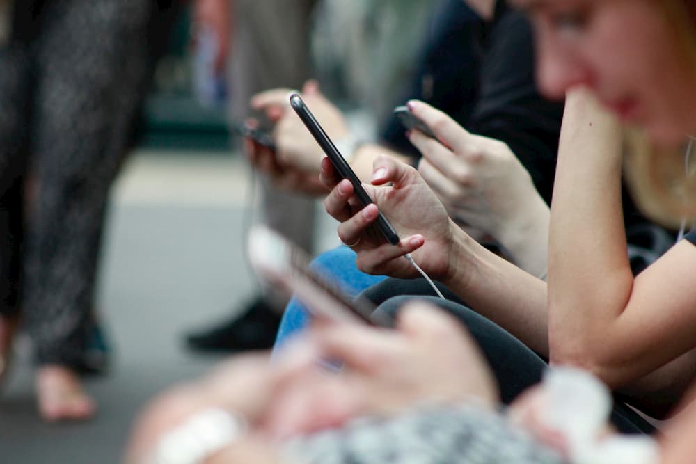 Imagen de varias personas usando sus teléfonos móviles en el metro