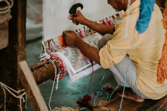 Man weaving a rug by hand