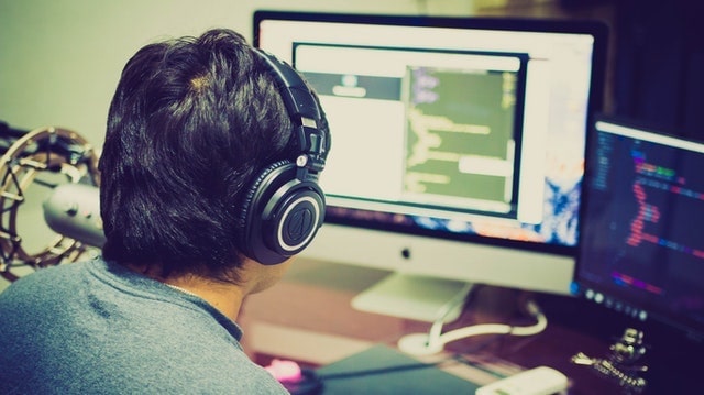 Man Working at Desk with Two Monitors