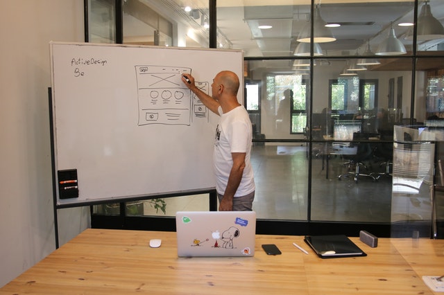 Man drawing on a whiteboard in an office