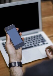 SEO Basics Man Sitting at Laptop Holding Phone