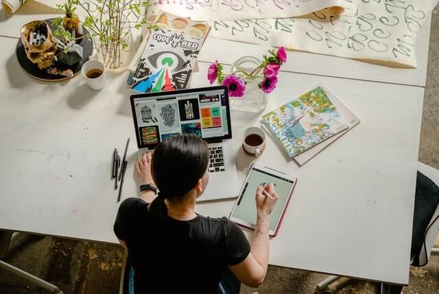 Overhead view of graphic designer working at table