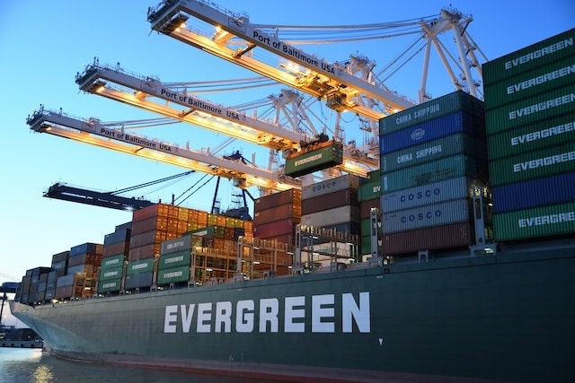 Cranes lifting shipping crates onto a ship