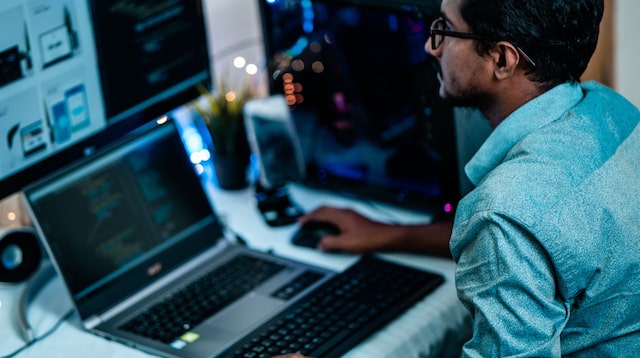 Developer at a desk with a laptop and second monitor