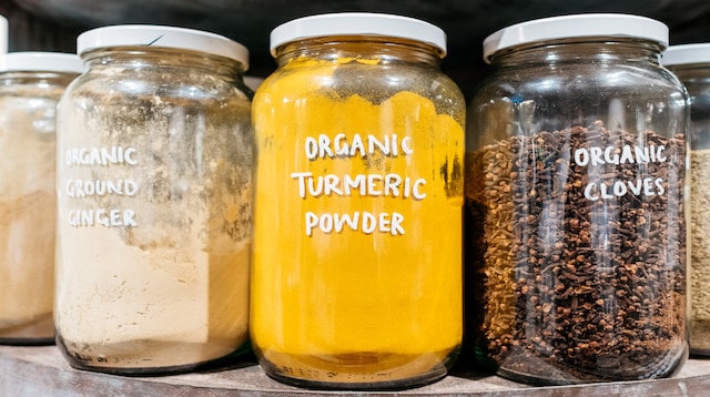 Dried spices in jars sitting on a shelf