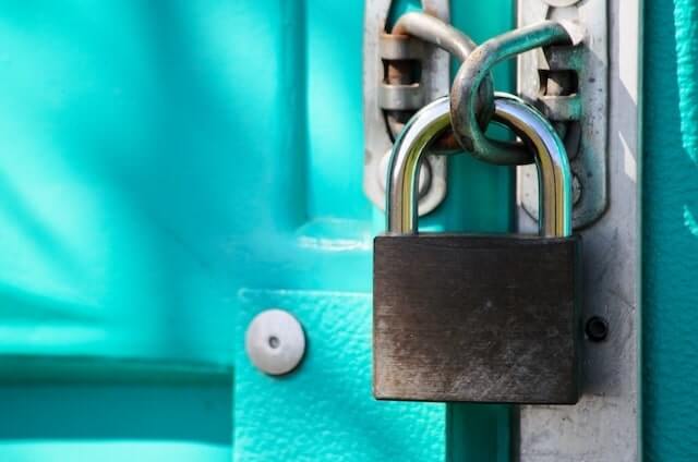 Grey padlock on a bright blue door