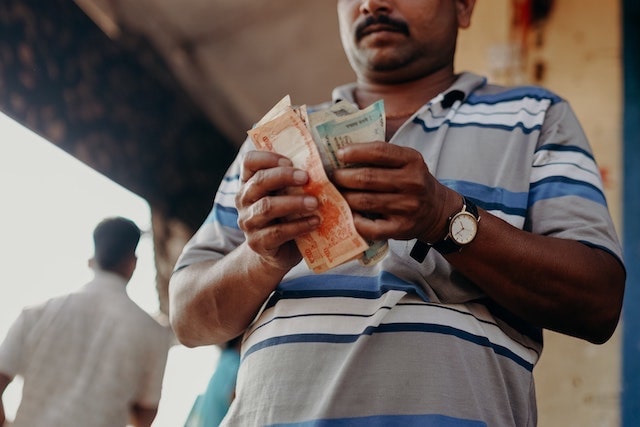 Man counting money outside a shop