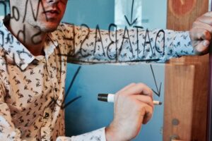 Man drawing a production process on a window