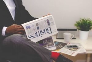 Man in a suit reading a business newspaper