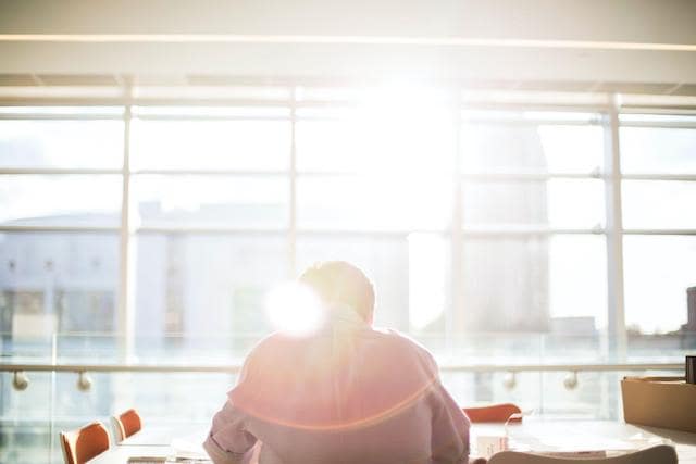 Man sitting in front of window with sunlight pouring over him