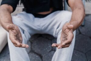 Man sitting on the groud with open hands