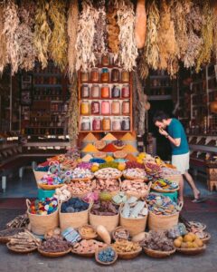 Man standing in marketplace looking at spices for sale