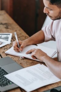 Man writing in a notebook at a desk