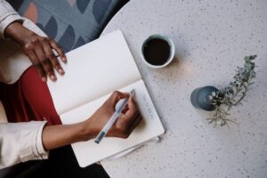 Person at a table writing in a notebook