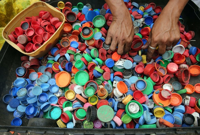 Person sorting plastic lids