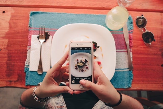 Person taking a photo of a meal with their mobile phone